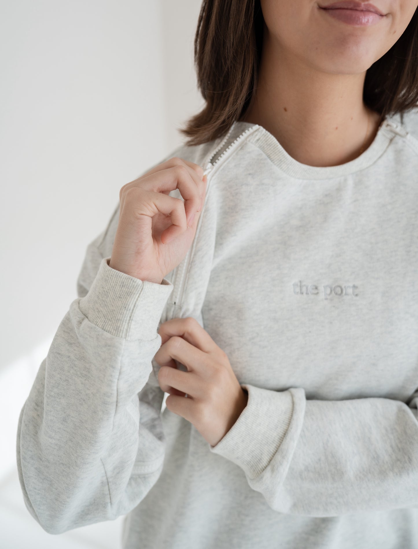 Person wearing a light gray port and iv accessible crewneck from The Port Studio. 