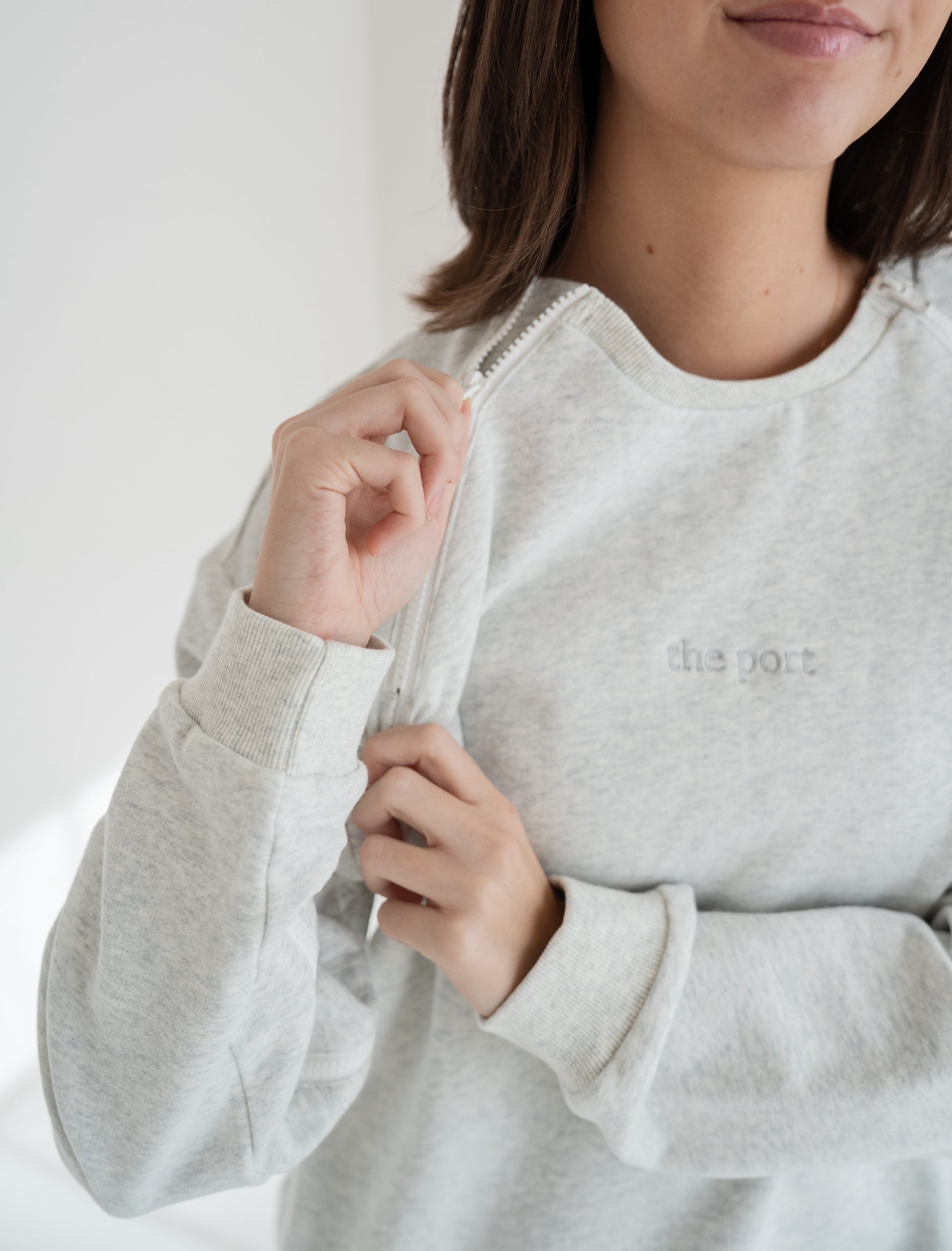 Person wearing a light gray port and iv accessible crewneck from The Port Studio. 